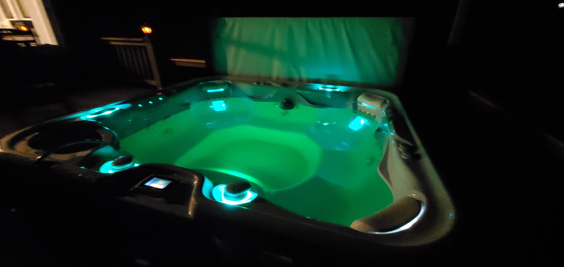 LED-lit hot tub glowing green at night